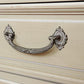 Decorative metal handle on a beige surface
