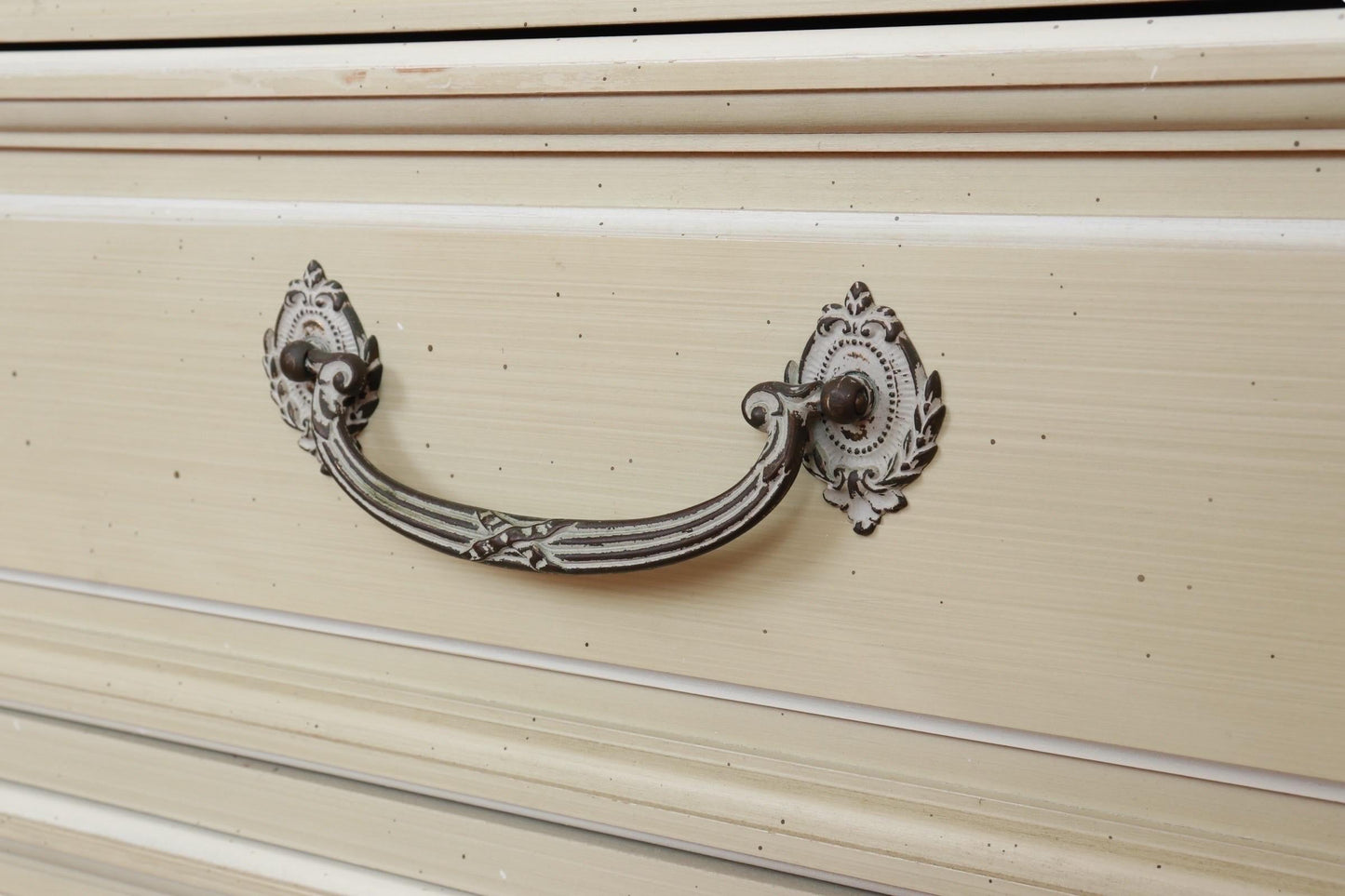Decorative metal handle on a beige surface