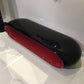 Black and red oval-shaped object on a white floor