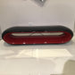 Modern black and red oval object on a white surface