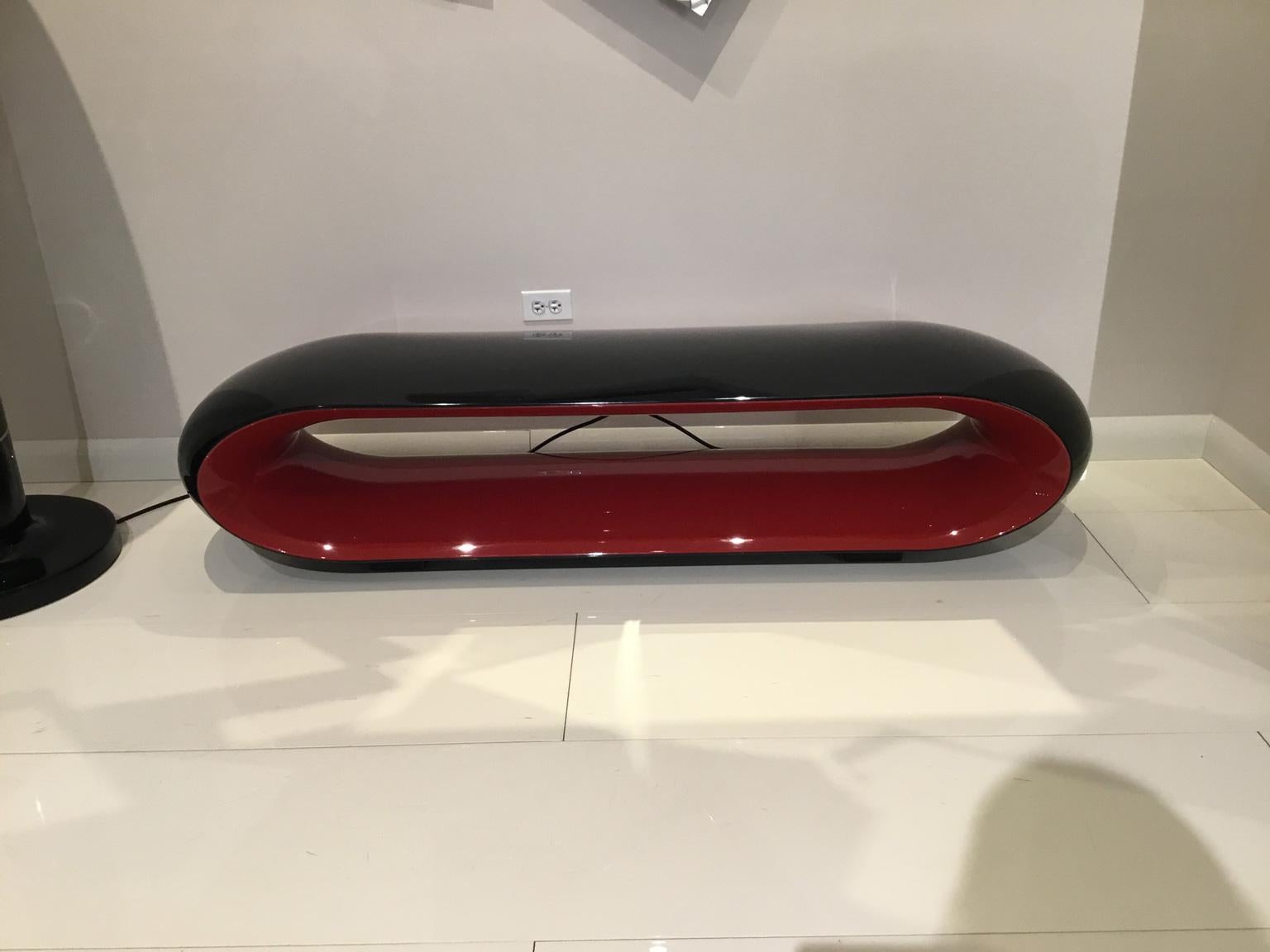 Modern black and red oval object on a white surface