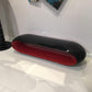 Modern black and red oval bench on a white tiled floor
