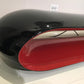 Black and red object on a white surface with a light gray wall in the background