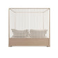 Beige crib with white mattress on a white background
