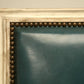 Close-up of a decorative gold frame with a textured border on a beige wall.