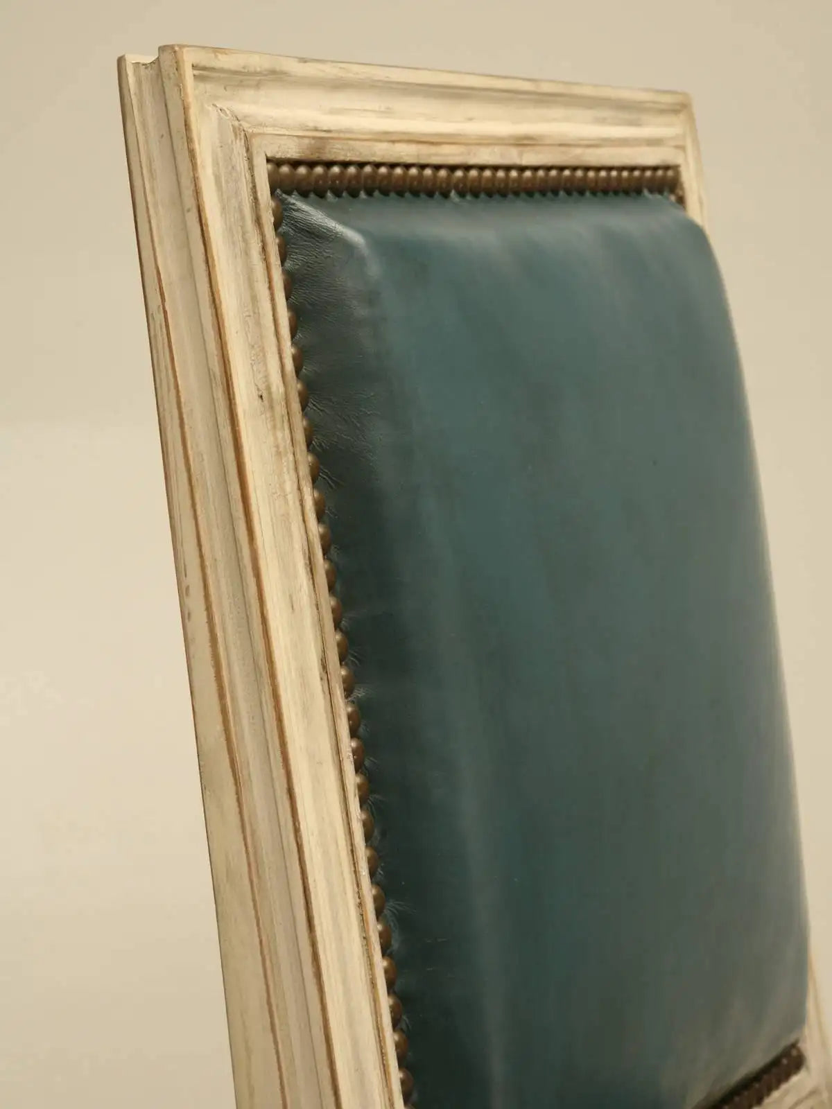 Teal fabric draped over a wooden frame against a beige wall