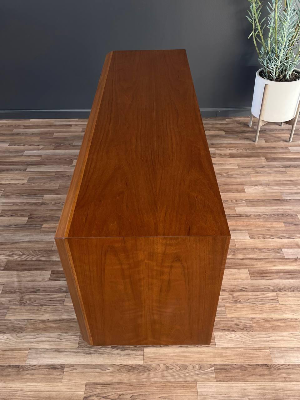 Wooden console table against a dark wall with a plant in the background