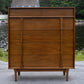 Wooden dresser with multiple drawers in an outdoor setting
