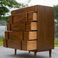 Wooden dresser with geometric design outdoors on a paved surface