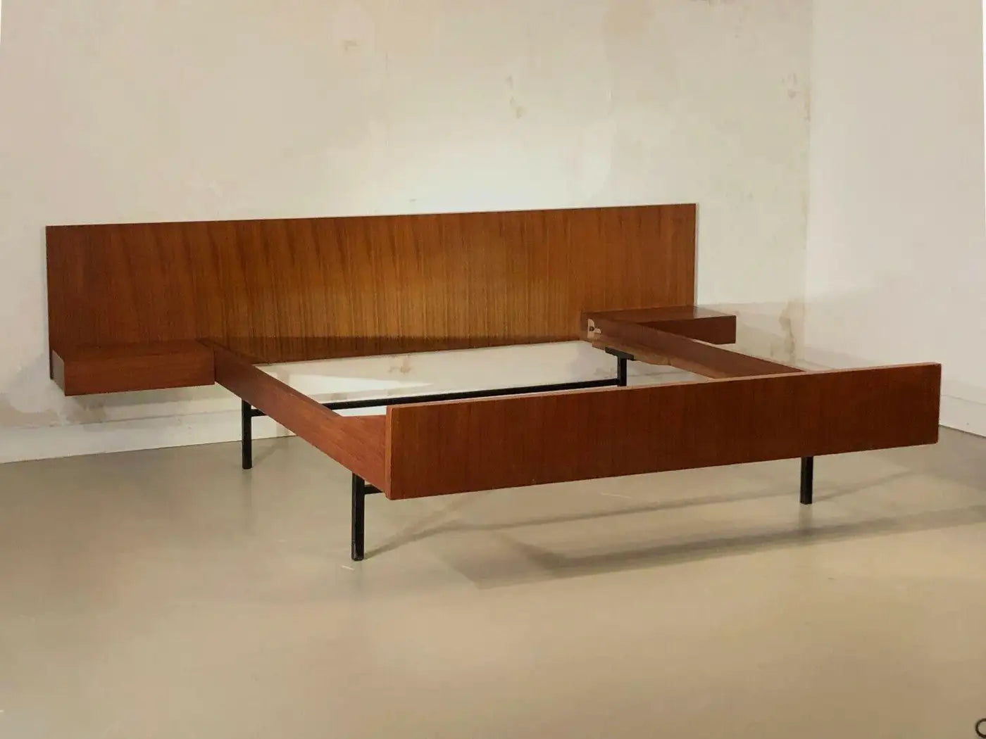 Wooden bed frame with headboard on a plain background