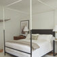 Four-poster bed in a bedroom with white bedding and a neutral color scheme.
