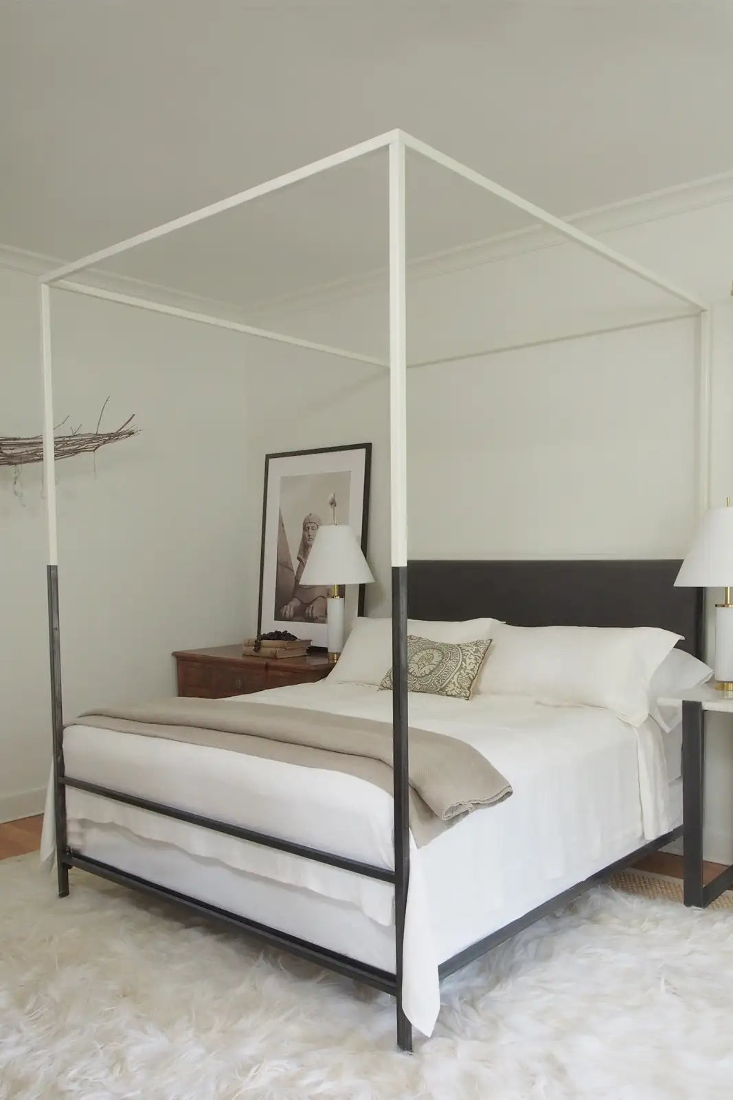 Four-poster bed in a bedroom with white bedding and a neutral color scheme.